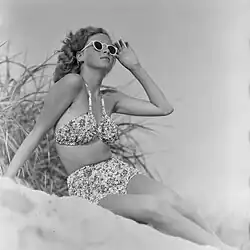 Žena v bikinách se slunečními brýlemi na pláži, 1938–1941