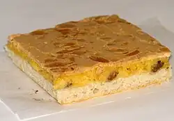 Barevná fotografie s pohledem se čtvercovým kouskem dvouvrstvého moučníku