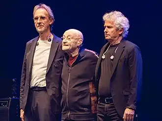 Sestava z let 1977–1996 — Mike Rutherford, Phil Collins a Tony Banks na snímku z roku 2022 při posledním koncertu.