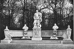 Celkový pohled na skupinu. Uprostřed půlkruhového podtsvce socha kurfiřta stojící na samostatném soklu. Za ním půlkruhová lavice, na které jsou umístěné dvě busty a pod nimi dva ležící lvi.