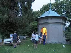 večerní fotografie glorietu, poblíž stojí skupina lidí