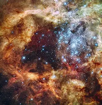 Složená fotografie R136 z Wide Field Camera 3 Hubbleova vesmírného dalekohledu v UV záření, viditelném a červeném světle