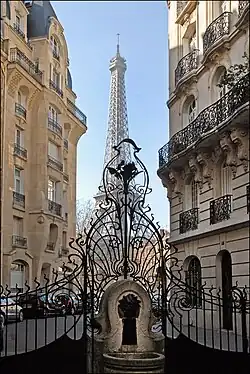 Exterior grill and fountain of 3 Square Rapp, with Eiffel Tower behind
