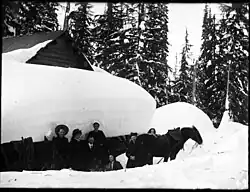 Skupina před zasněženou chatou, 1902