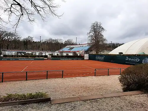 Antukový dvorec a vzadu tribuna stadionu Grafové