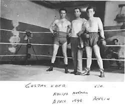 Černobílá fotografie boxerského ringu se třemi muži