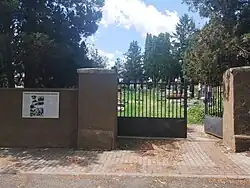 Hřbitov v Mutějovicích s informační tabulkou na hřbitovní zdi u vstupu