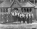 Skupinová fotografie před roubeným kostelem, Heddal