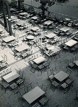 Restaurant terrace, vintage print, ferrotypizovaný bromostříbrný želatinový tisk na papíru chamois; rozměr: 24,5 x 18 cm. Fotografovo razítko Foto H. Koch Halle/S. a anotace tužkou na rubu snímku. Mezi lety 1929 a 1932.