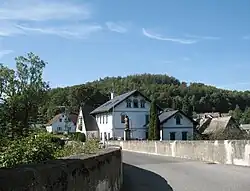 Pohled na kopec Na Chatkách se skalní vyhlídkou od silničního mostu přes Smědou v Hejnicích