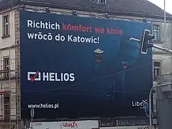 Reklamní billboard ve slezštině s nápisem „Pravá pohoda v kině se vrací do Katovic!“