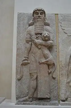 Socha Gilgameše, který drží v levé ruce lva. Lev je proti Gilgamešovi disproporčně malý.