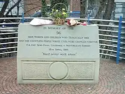 Památník na stadiónu Hillsborough s nápisem: „Na památku 96 mužů, žen a dětí, kteří tragicky zahynuli, a nesčetných lidí, jejichž životy byly navždy změněny. Semifinále FA Cupu. Liverpool vs. Nottingham Forest. 15. dubna 1989. Nikdy nebudete kráčet sami“