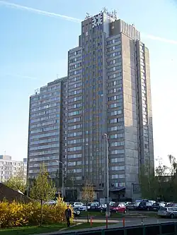 dva věžové domy s hodinami na střeše, propojené v nejvyšším patře lávkou