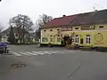 Ladovskými motivy zdobená hospoda U  Sejků, v pozadí bývalá škola