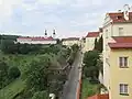 Z okna sekretariátu na velkou strahovskou zahradu, Švédské velvyslanectví, Strahovský klášter a na horní část ulice Úvoz