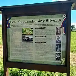 Informační tabule u památníku v místě seskoku Alfréda Bartoše a Jiřího Potůčka (Podmoky, okr. Nymburk)