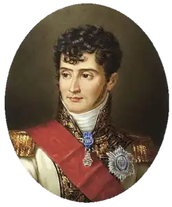 Barevná reprodukce portrétu muže, který má černé kudrnaté vlasy, bílou uniformu, přes ní červený pás.