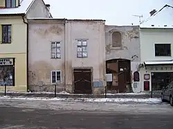 Masarykovo náměstí čp. 20 (uprostřed) a čp. 19 (vpravo). Obytné domy, které vznikly přestavbou budov zaniklého kláštera a kostela. Nad vjezdem nika pro sošku Panny Marie.