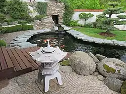 Jezírko s Koi kapry, v popředí japonská lucerna, v pozadí bonsaj