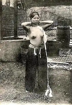 Mladá annamská žena dokončuje svou toaletu