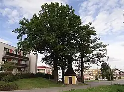 Kaple na návsi, znehodnocené panelovou zástavbou