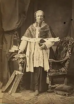 Kanovník Foulon v kapitulním chórovém oděvu s kolárkem ve formě tabulek