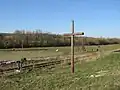 Kříž mezi tratí a silnicí západně od Kojovic