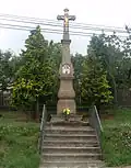 Kříž u cesty v obci s novodobým litinovým korpusem Krista