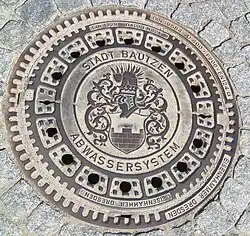 Fotografie poklopu kanálu se znakem Budyšína