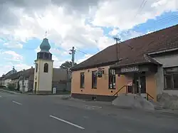 Hostinec a zvonice při hlavní silnici, směr Ždánice