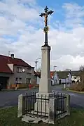 Kříž v ohrádce ve vesnici