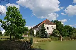 Pohled ze středu vesnice, vpravo je zbytek gotické zdi