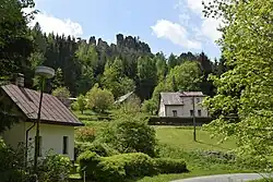 Pohled na chalupy v obci v pozadí se Suchými skalami