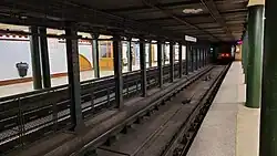 pohled do stanice s odjíždějící soupravou metra v pozadí