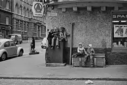 Kolme tyttöä lukemassa jakokaapin päällä Meritullinkadulla Liisankadun kulmassa