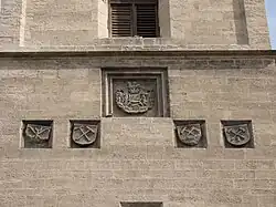 Původní znaky horníků a novější znak města na věži