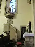 Interiér kostela, kazatelna a nad ní socha sv. Jana Křtitele. Vpravo mensa bývalého bočního oltáře.