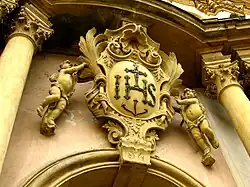 Detail fasády se znakem jezuitského řádu