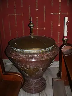 Křitelnici z jednoho kusu červeného belgického mramoru a reliéfní práce z mosazi vytvořil Julius Pelikán v roce 1932