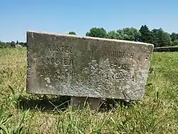 Nápis na kamenné desce před vstupem ke kostelu