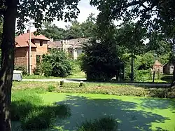 Kvasetice, rybníček v centru a v pozadí ruina zámku