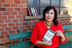 Lenka Chalupová s knihou Kyselé třešně (2020) v Lověšicích, kde se děj románu odehrává.