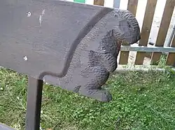 Detail vyřezávaného bobra na konci opěráku lavičky