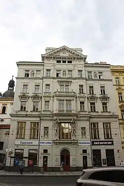 Spolkový dům v pozadí s kostelem Nejsvětější trojice