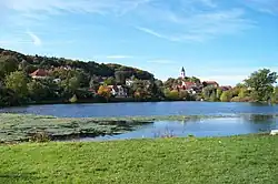 Pohled přes rybník ze severovýchodního břehu ke kostelu a k oboře (2012)