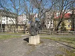 V místech za zábradlím u komunikace poblíž plastiky Spirála ve Studentské ulici v Litvínově Bílý potok protéká pod zemí, načež po několika metrech opět vychází na povrch