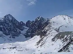 Lomnický štít (vlevo), přes Vidlový hrebeň Kežmarský štít (uprostřed) a Huncovský štít (vpravo) ze Skalnatého plesa