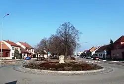 Podlouhlá náves s parkem, v severní části stojí kostel