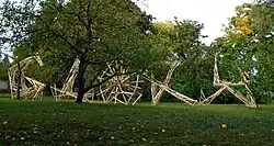 v parku stojící stylizovaný nápis GLORY, 2-3 metry vysoká písmena prostorově seskládána z dřevěných laťověk